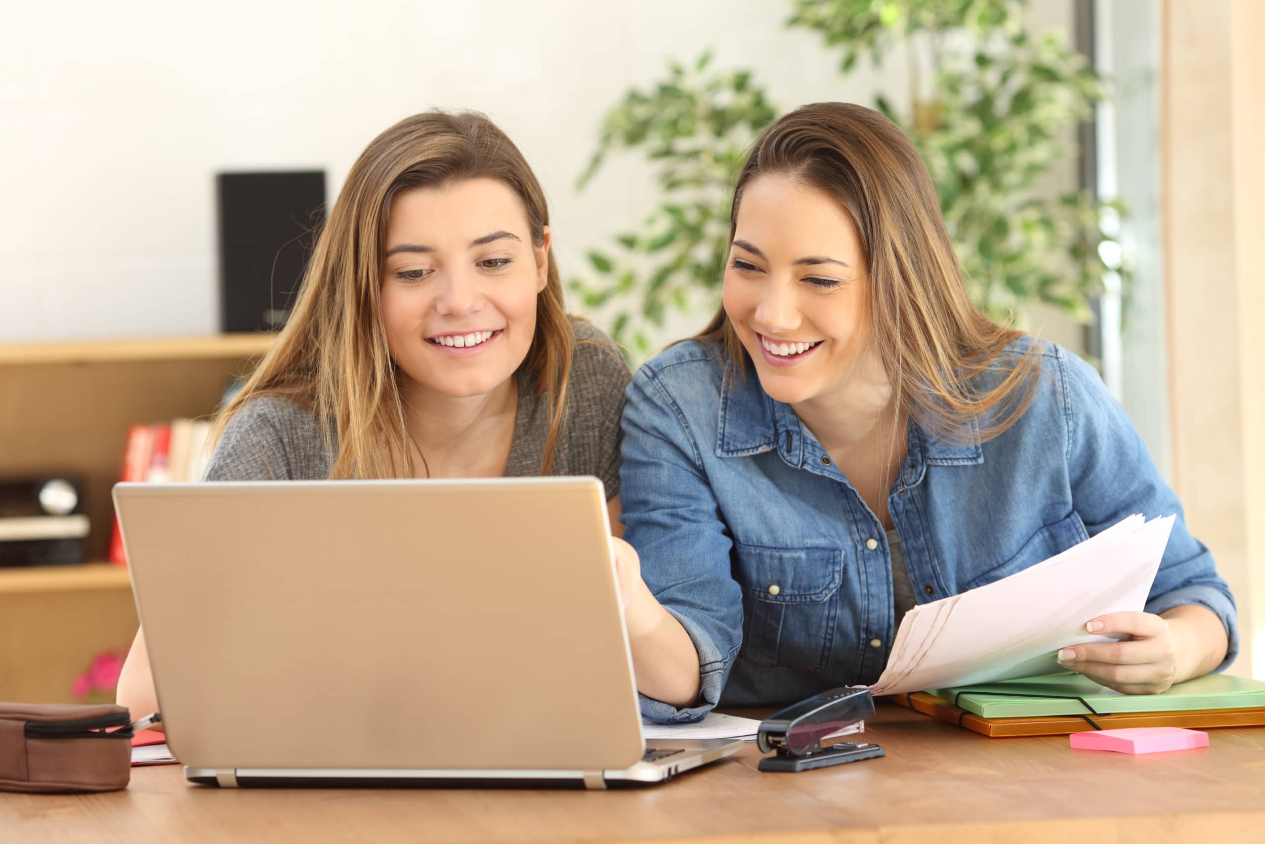 Two people reviewing information together on a laptop