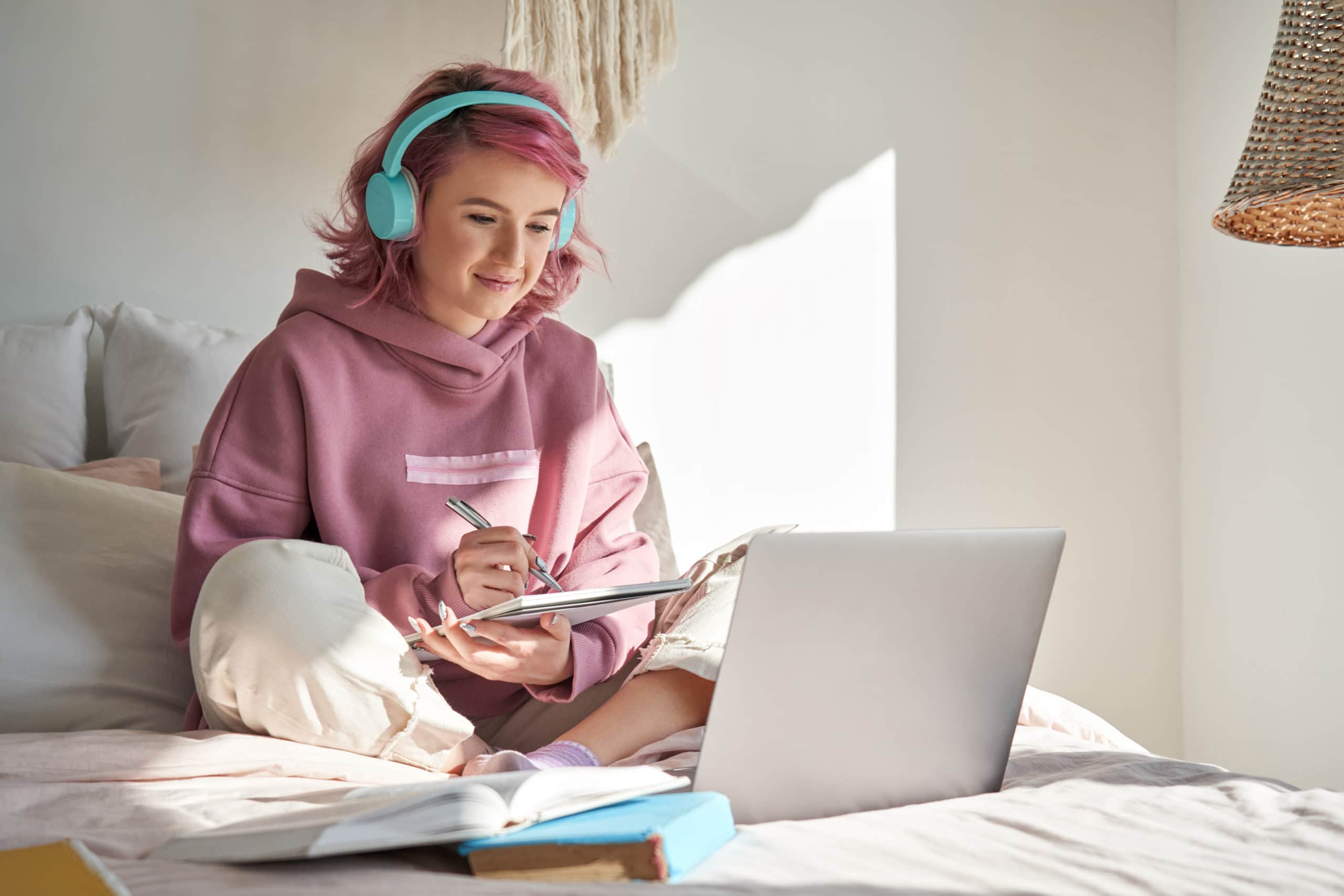 Young borrower woman on laptop and writing in notebook