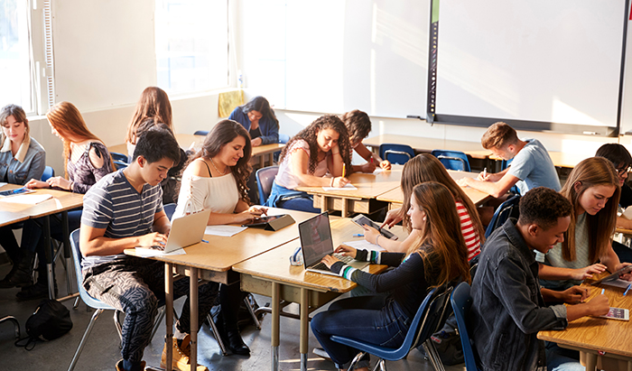Students Sitting At Desks In Classroom