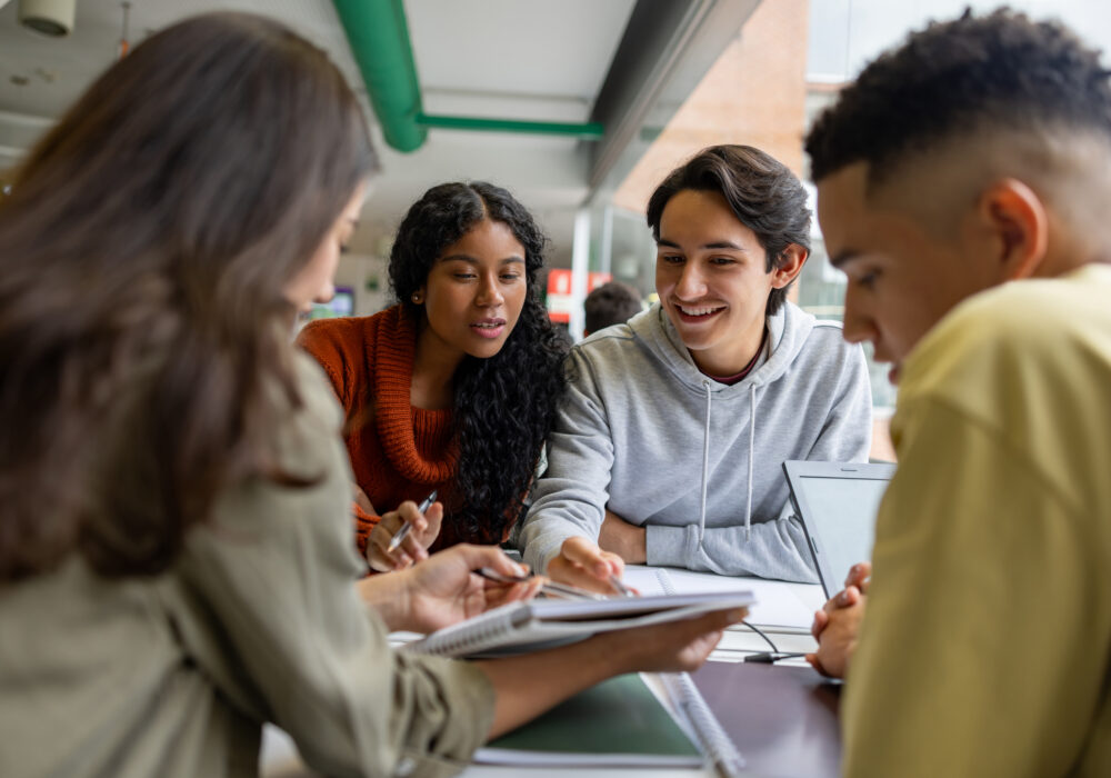 Happy group of students studying together at the library